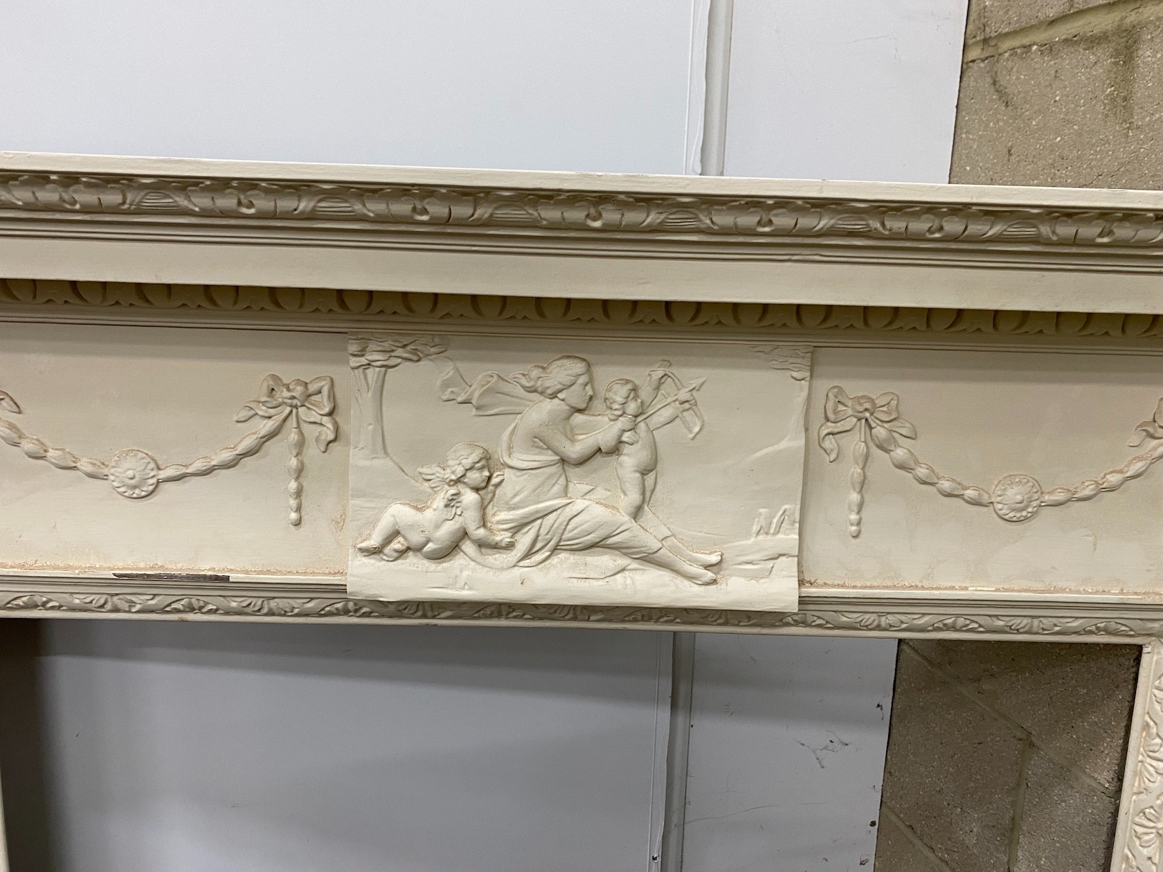 A George III style painted pine and composition fire surround with classical frieze, width 144cm, depth 17cm, height 143cm